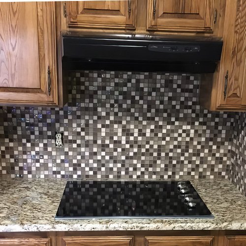 Glass mosaic tile backsplash behind cooktop